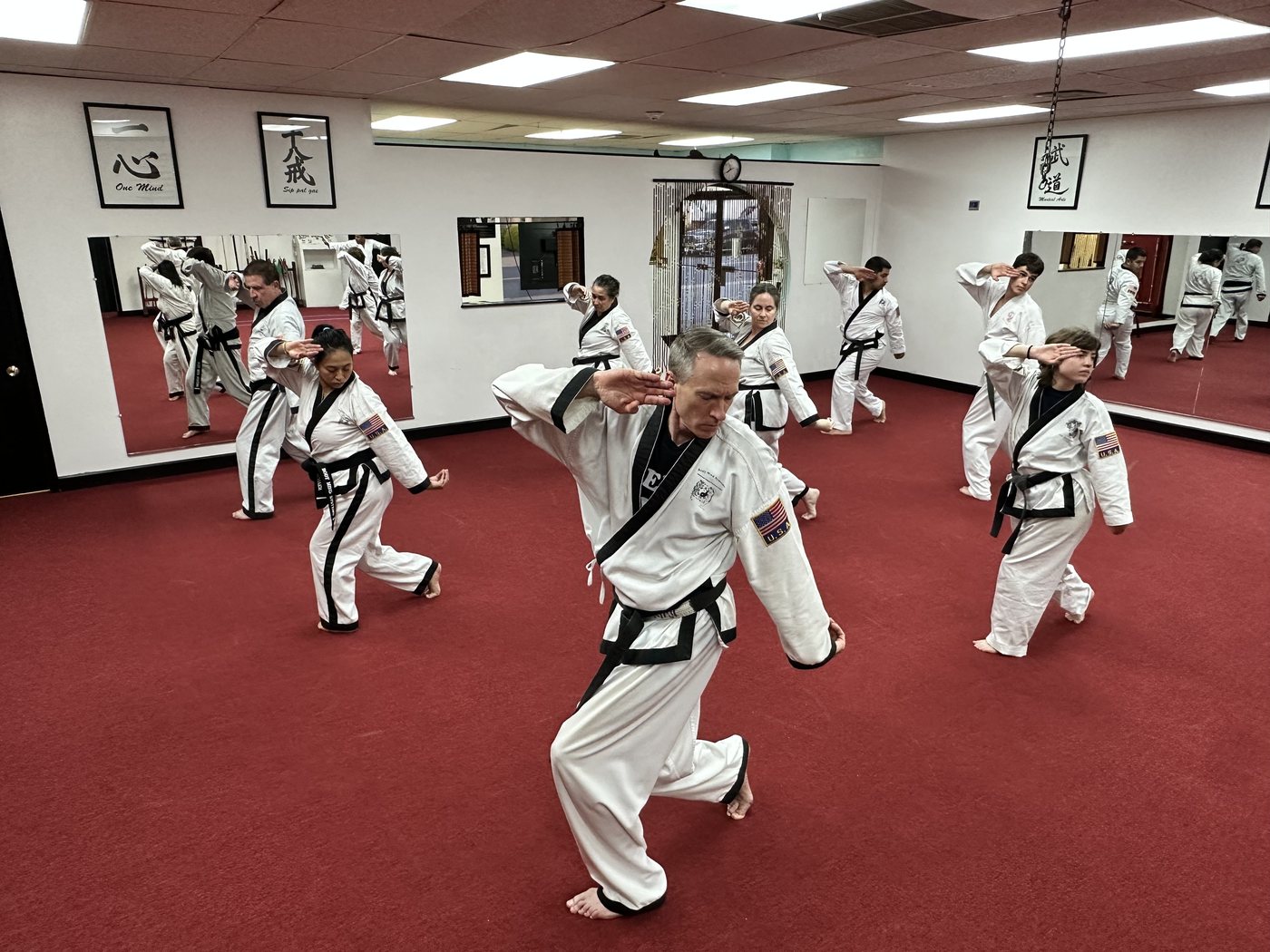 White-gi class practicing knife-hand strikes